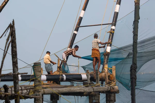 Kochin, Hindistan-Şubat 24: Balıkçılar üzerinde 24 Şubat 2013 Kochin, Hindistan'da şehir noktasında. Hint balıkçı balıkçılık için geleneksel Çince ağ kullanma