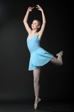 Güzel genç sarışın balerin siyah arka planda dans 