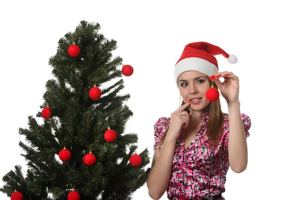 装饰圣诞树的圣诞帽子的妇女 — 图库照片