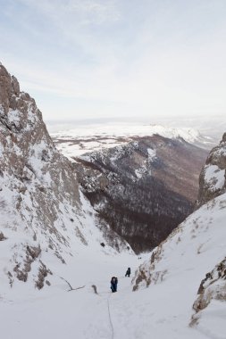 Karlı Kırım dağlarında yürüyüşçüler