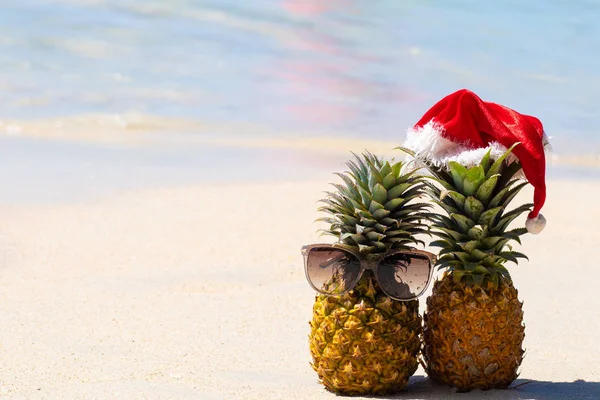 Due Amici Ananas Bicchieri Cappello Natale Sulla Sabbia Bianca Con — Foto Stock