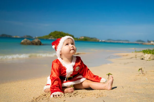 Baby Przebrany Świętego Mikołaja Brzegu Morza Niebieski Białym Piaskiem — Zdjęcie stockowe