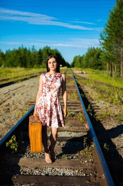 Tren ve seyahat için bekleyen pistlerde kız