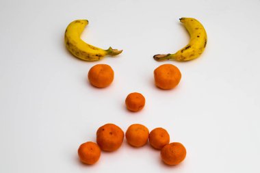 Meyve taze meyve ile yapılmış beyaz background.ace üzerinde gelen yüz. muz, mandalina