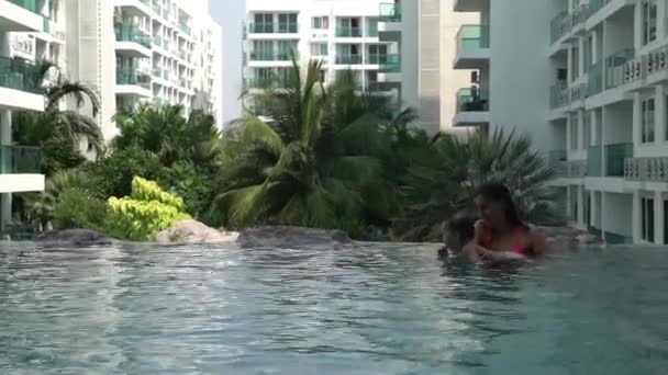 Felice Madre Insegna Nuotare Figlia Piscina Uno Sfondo Alberi Cocco — Video Stock
