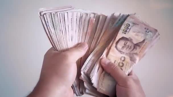 Close-up handen tellen van thousansds Thaise baht geld. Close-up van menselijke tellen Thaise bankbiljet, richman graaf en honderd baht rekeningen op houten tafel, op een witte achtergrond te houden. Close up van thailand — Stockvideo