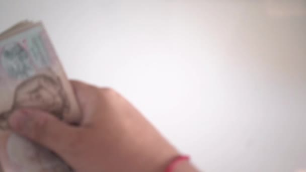 Close-up handen tellen van thousansds Thaise baht geld. Close-up van menselijke tellen Thaise bankbiljet, richman graaf en honderd baht rekeningen op houten tafel, op een witte achtergrond te houden. Close up van thailand — Stockvideo