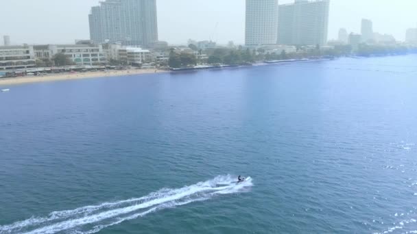 Drone антена повільний рух постріл над малим ходом човен човен рвалися подорожі до нових напрямків відпочинку концепції. Водний мотоцикл їде на фоні місто Паттайя Паттайя, Таїланд. — стокове відео