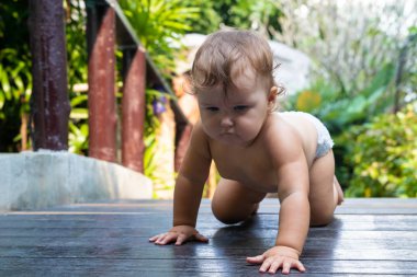 9 ay çocuk bahçesinde çocukların, mal kavram eğitimi çimenlerin üzerinde tarar. Çıplak bacaklar. Sağlıklı bebek