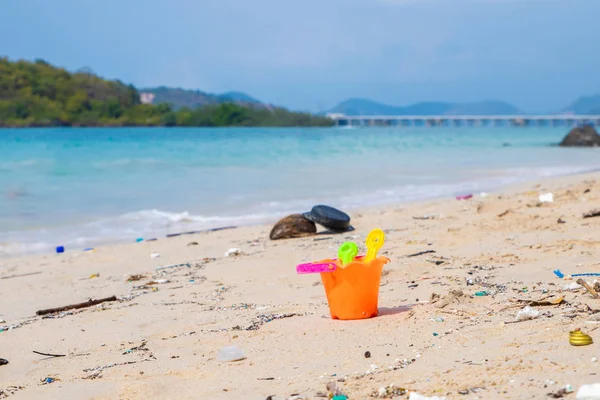 Schmutzige Strände. Verursacht durch das Dumping von undisziplinierten. Verschmutzung am Strand des tropischen Meeres. Umweltverschmutzung. Kinderspielzeug am Sandstrand. — Stockfoto