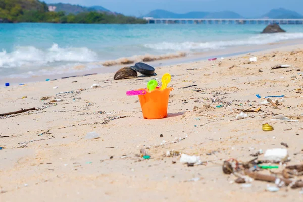 Schmutzige Strände. Verursacht durch das Dumping von undisziplinierten. Verschmutzung am Strand des tropischen Meeres. Umweltverschmutzung. Kinderspielzeug am Sandstrand. — Stockfoto