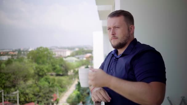 Jeune homme d'affaires admirer la vue et boire du café debout sur la terrasse — Video