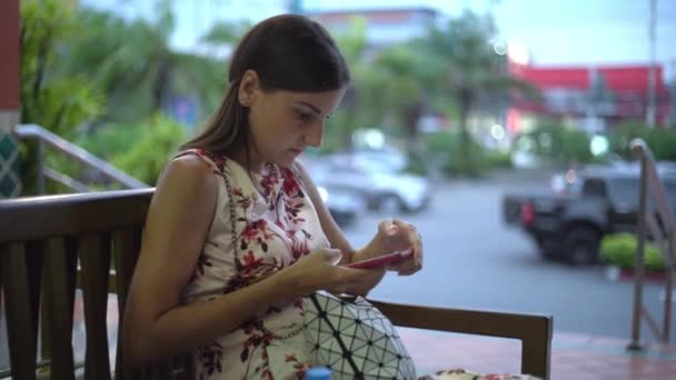 Wanita mendapat pesan dan mengambil telepon untuk membacanya tersenyum — Stok Video