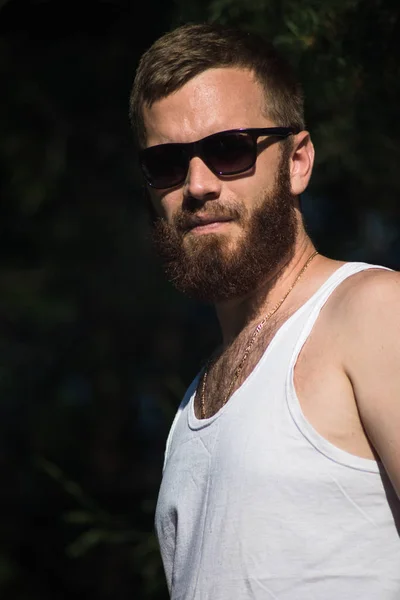 Retrato de um homem sexy com uma barba em óculos de sol . — Fotografia de Stock