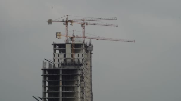 Vue du dessus d'un nouveau bâtiment de grande hauteur en construction. Une grue de chantier. architecture gratte-ciel — Video