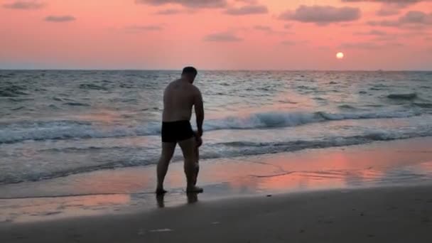 Pai e filha estão andando sobre as ondas, andando ao pôr do sol — Vídeo de Stock