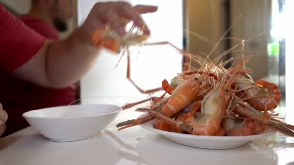 Homem em uma loja de frutos do mar colocando camarão fervido em um prato. Fotografar close-up . — Vídeo de Stock