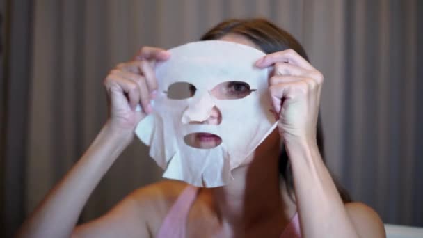 La chica puso una máscara en la cara en casa. El concepto de belleza — Vídeos de Stock