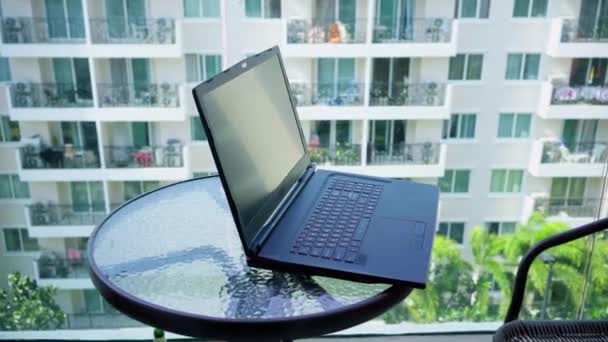 Чорний ноутбук на скляній стільниці крупним планом — стокове відео