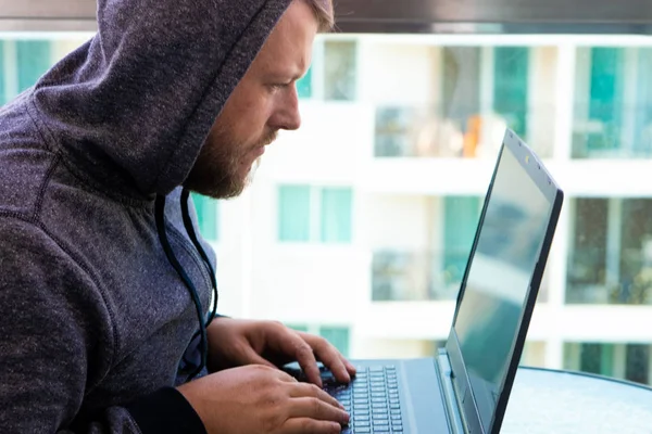 Кіберзлочинність, хакерство та концепція технології - чоловічий хакер, що пише код або використовує комп'ютерну вірусну програму для кібер-атаки — стокове фото
