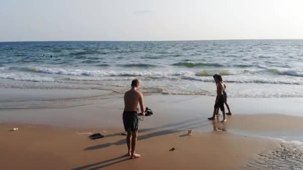 Táta se na fotoaparát děti pobíhají děti na pláži — Stock video