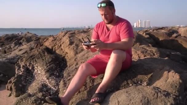 Un uomo controlla un drone al tramonto — Video Stock