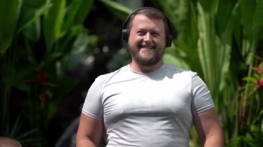 Sakallı komik adam giysilerini üzerinde koyar, müzik döner, enerjik müzik, dans etmek dinliyor. Yakın çekim