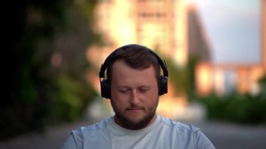 Sakallı komik adam giysilerini üzerinde koyar, müzik döner, enerjik müzik, dans etmek dinliyor. Yakın çekim.