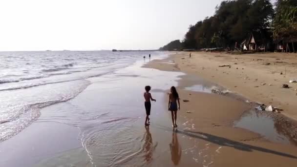 Barn ha roligt i vattnet utomhus. Glada barn glad liten pojke och en flicka kör längs havsstranden — Stockvideo