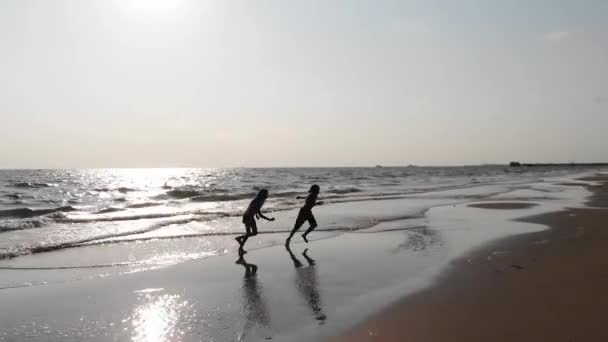 Barn ha roligt i vattnet utomhus. Glada barn glad liten pojke och en flicka kör längs havsstranden — Stockvideo