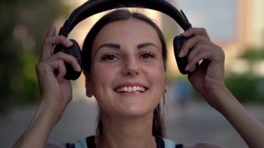 Kız koyar kulaklıktan içerir ve telefonda müzik dinler ve dans. yakın çekim. 4k