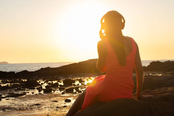 Κορίτσι σε ακουστικά να ακούτε μουσική στην πόλη για το ηλιοβασίλεμα. — Φωτογραφία Αρχείου