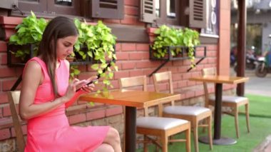 Kadın telefonda konuşurken sokakta bir kafede iletileri gönderir. 4k