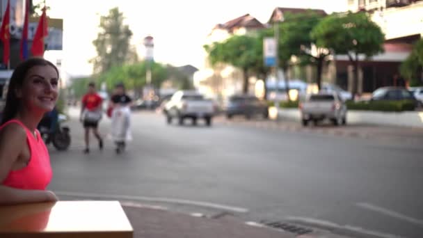 Kvinna väntar på någon på ett café på gatan av mötet, vifta med handen till en vän, 4k — Stockvideo