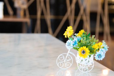 Ahşap masa üzerinde beyaz bir bisiklet güzel çiçeklenir. Ahşap masa üzerinde beyaz bisiklet içinde güzel çiçekler.