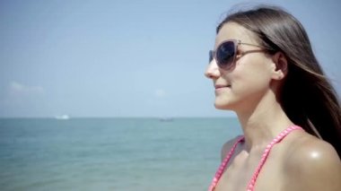 güneş gözlüklü kız görünüyor ve deniz hayran. yakın çekim. 4k.