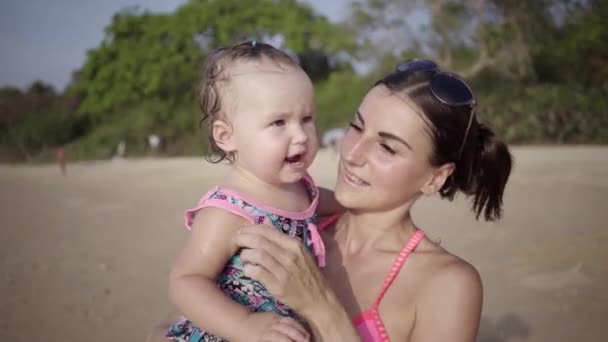 Mamá y su hija en la playa junto al mar de cerca. 4k — Vídeos de Stock