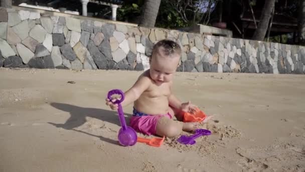 Chica un año juega en la arena en la playa. Concepto: niños, infancia, verano, libertad, niños, bebé. 4k . — Vídeos de Stock