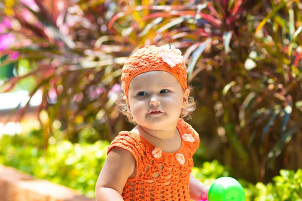 オレンジ ニット ドレスと帽子で女の子は驚いて、高慢、悲鳴、叫び、彼女の手を発生させます。子供ファッションのコンセプト. — ストック写真