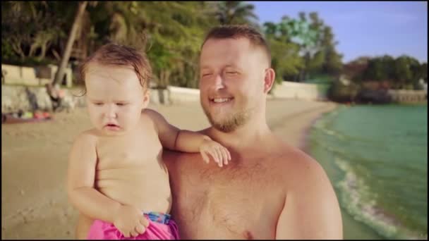 Happy dad carries in her arms a cute baby on a beautiful beach in Thailand, Pattaya. 4k. — Stock Video