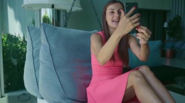 öğleden sonra ağır çekim bir asılı yatakta yatıyordu süre telefonda Skype'takonuşurken genç kız.