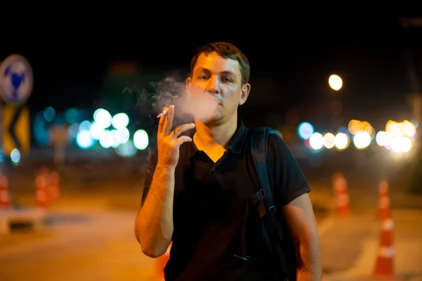 Uomo fumare una sigaretta per strada di notte . — Foto Stock