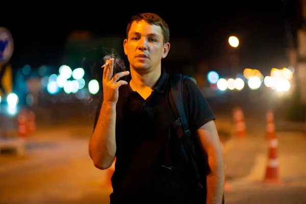 Hombre fumando un cigarrillo en la calle por la noche . —  Fotos de Stock