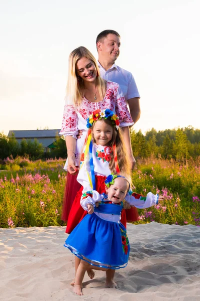 Large family in ethnic Ukrainian costumes sit on the meadow, the concept of a large family. — Stock Photo, Image