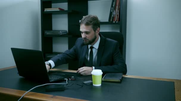 Szakállas üzletember ül az irodában, a laptop, a férfi felháborodott, a lassú mozgás. — Stock videók