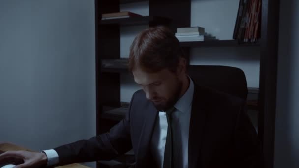 Бородатый бизнесмен работает в офисе за компьютером, мужчина смотрит на свой рабочий план, замедленная съемка — стоковое видео