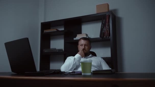 Hombre de negocios barbudo en la oficina en el ordenador se mete la nariz y se apresura a los gnarls, el macho está aburrido y triste, cámara lenta — Vídeo de stock