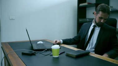 dizüstü bilgisayarın arkasındaki ofiste oturan işadamı vurguladı, erkek işçi telefon ve alır kızgın, yavaş hareket görünüyor.