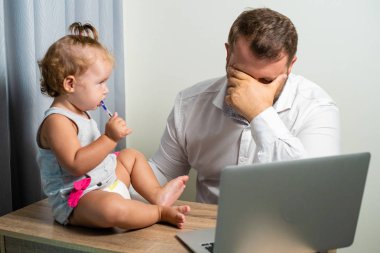 Freelancer iş kavramı. yorgun baba çalışma vasıl ev ile bir dizüstü bilgisayar, onun kollarına bebek tutan