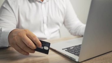 Alışveriş online kavram. adam elleri kredi kartı tutan ve dizüstü bilgisayar kullanarak. erkek el masada kartı çalar
